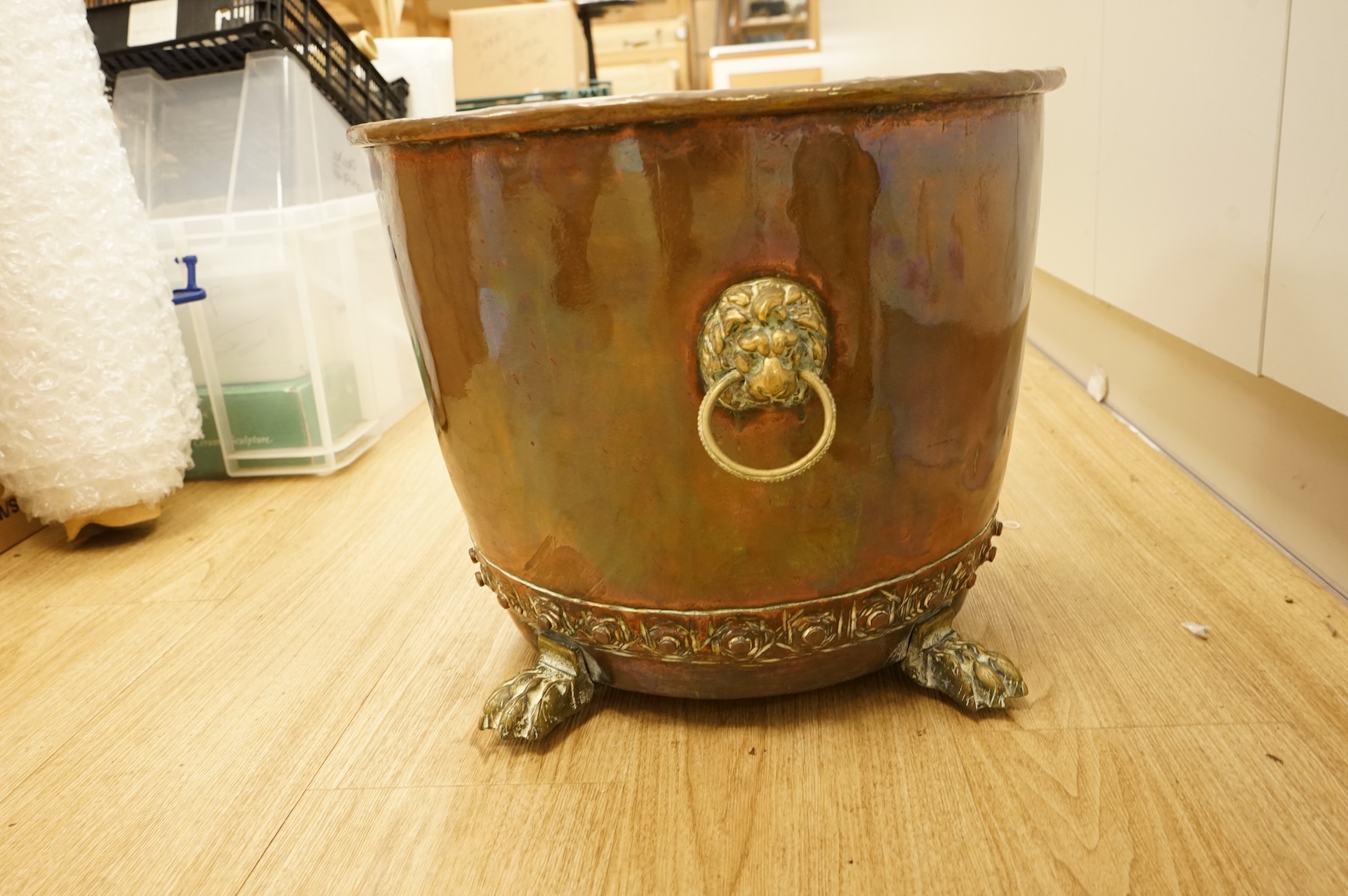A copper log bucket with paw feet and lion-mask handles, 43cm in diameter